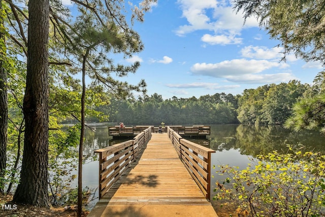 dock area with a wooded view and a water view