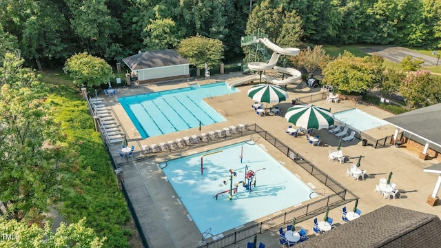 community pool with a water slide and fence