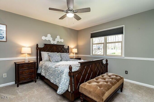 bedroom featuring a ceiling fan, light colored carpet, and baseboards