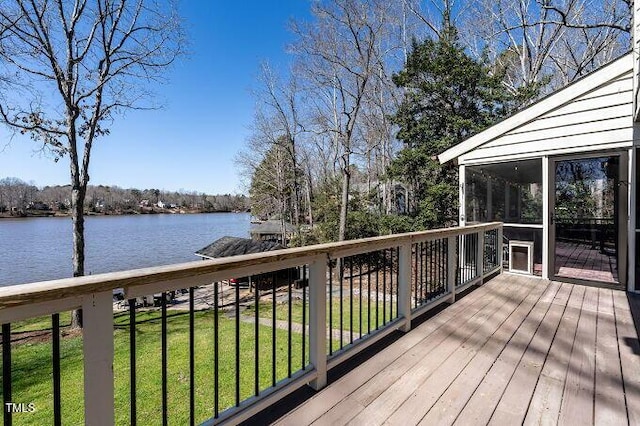 deck with a water view, a lawn, and a sunroom