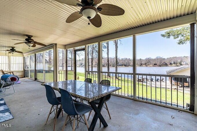 unfurnished sunroom featuring a water view and ceiling fan