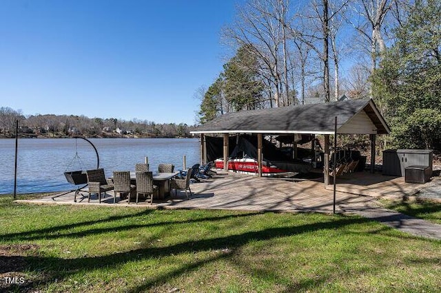 view of dock with a lawn and a water view