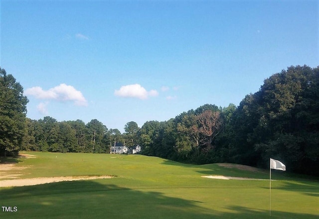 view of community featuring view of golf course and a lawn