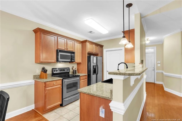 kitchen with a peninsula, stainless steel appliances, crown molding, a kitchen breakfast bar, and brown cabinets