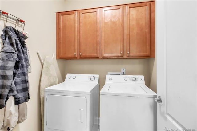 washroom with cabinet space and washing machine and clothes dryer