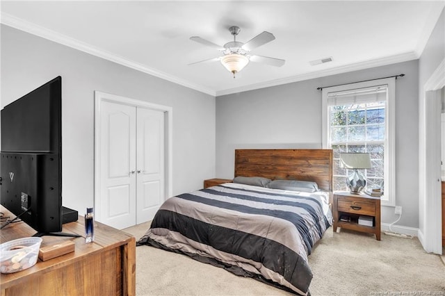 bedroom with visible vents, ceiling fan, ornamental molding, light carpet, and a closet