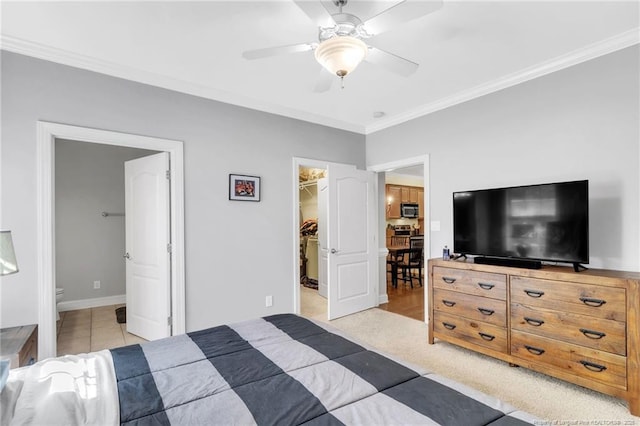 bedroom with a walk in closet, a closet, and ornamental molding