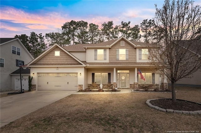 craftsman-style home featuring a garage, roof with shingles, covered porch, and concrete driveway