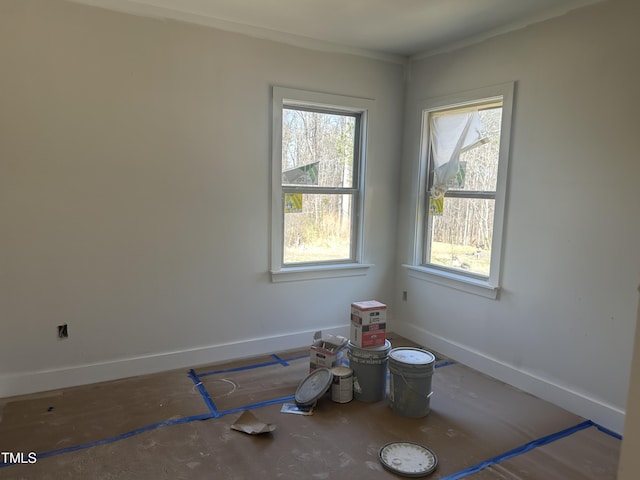 unfurnished room with baseboards