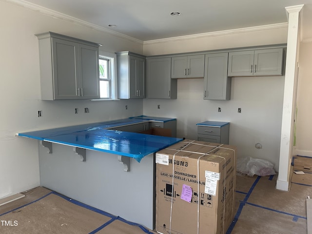 kitchen featuring a peninsula, a kitchen breakfast bar, crown molding, and gray cabinetry