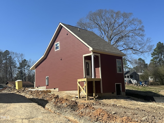 view of side of property with a shingled roof