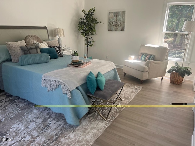 bedroom with baseboards and wood finished floors