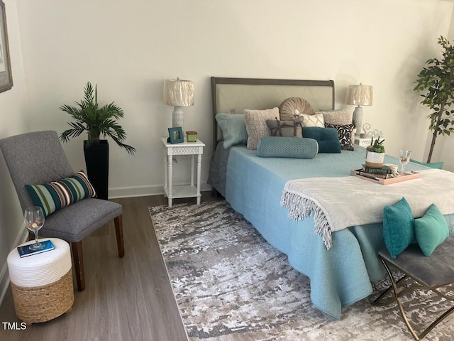 bedroom with baseboards and wood finished floors