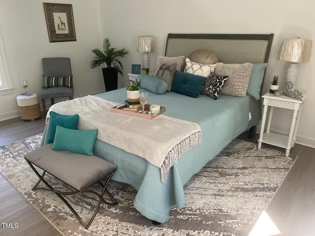 bedroom featuring baseboards and wood finished floors