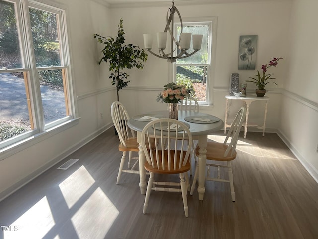 dining area featuring visible vents, baseboards, wood finished floors, and a chandelier