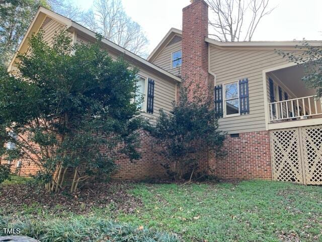 view of home's exterior with crawl space, a yard, and a chimney