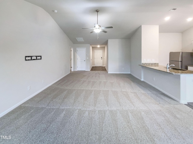 unfurnished living room featuring ceiling fan, baseboards, carpet, and vaulted ceiling