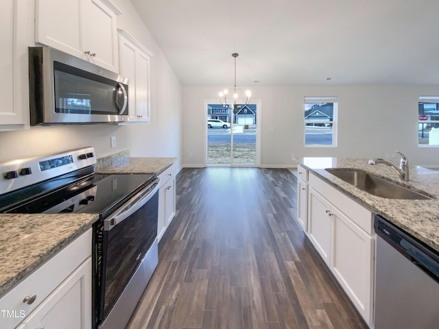 kitchen with a sink, appliances with stainless steel finishes, a notable chandelier, white cabinets, and dark wood-style flooring