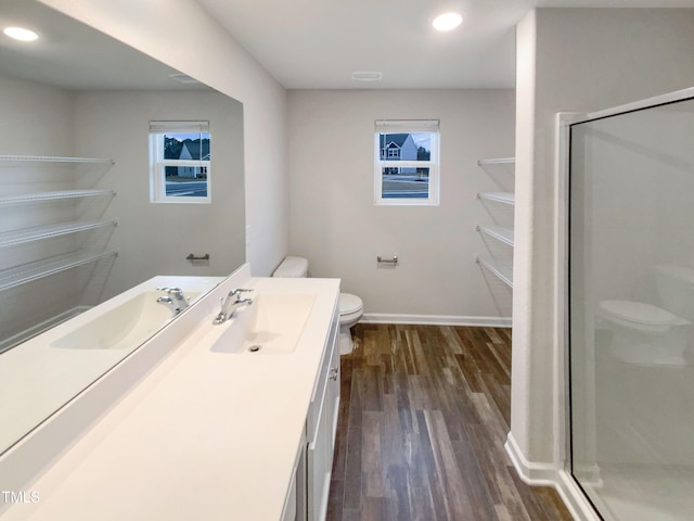 full bath featuring baseboards, toilet, a stall shower, wood finished floors, and vanity