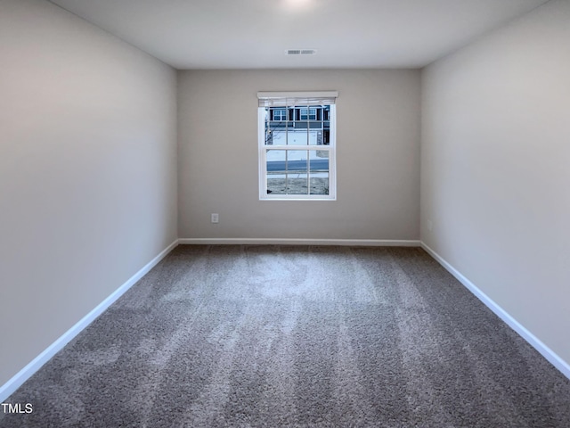 unfurnished room with visible vents, carpet, and baseboards