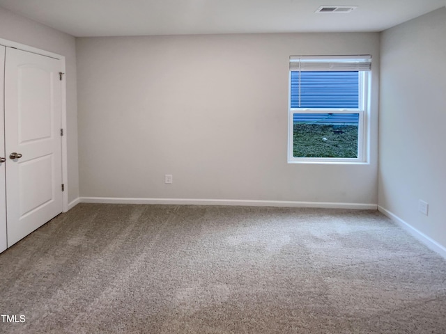 unfurnished room with visible vents, baseboards, and carpet flooring