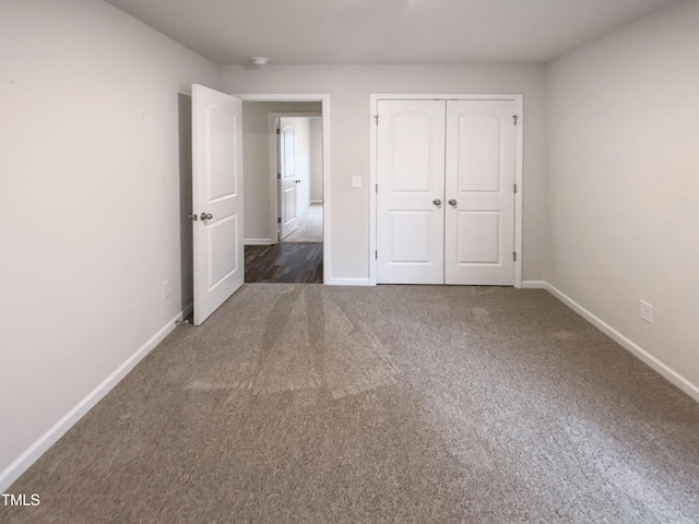 unfurnished bedroom with a closet, baseboards, and carpet floors