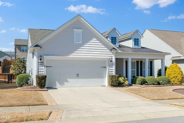 view of front facade featuring an attached garage, concrete driveway, a standing seam roof, and metal roof