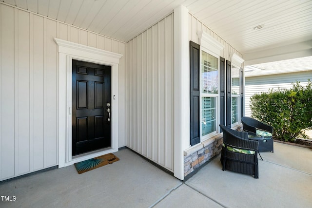 entrance to property with a porch and stone siding