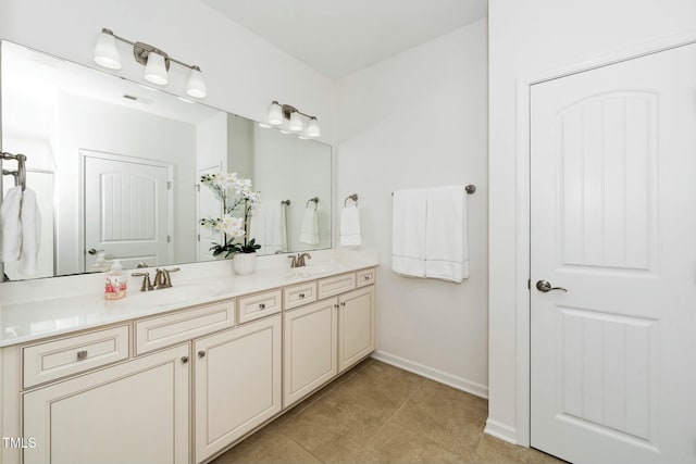 full bathroom featuring tile patterned flooring, double vanity, baseboards, and a sink