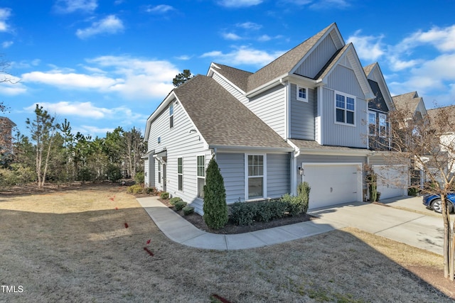 view of front of home featuring concrete driveway, a garage, a front yard, and a shingled roof