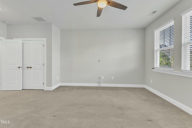 empty room with carpet flooring, baseboards, and visible vents