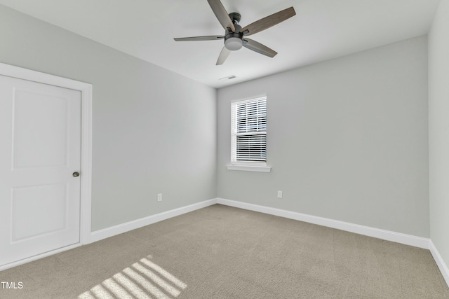 carpeted empty room with visible vents, ceiling fan, and baseboards