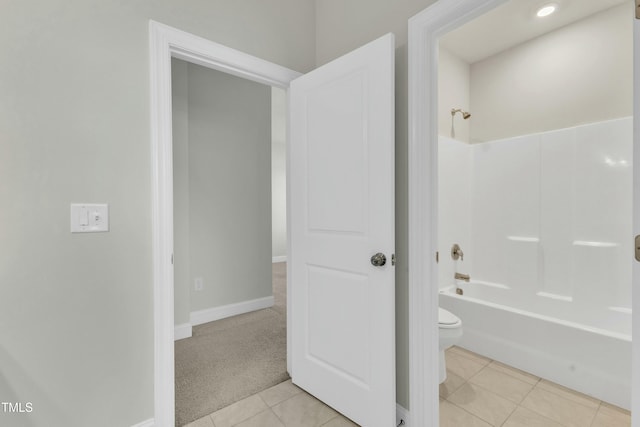 bathroom with tile patterned floors, toilet, shower / tub combination, and baseboards