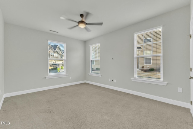 spare room with visible vents, carpet flooring, a ceiling fan, and baseboards