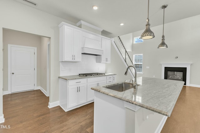 kitchen with visible vents, a sink, dark wood-style floors, white cabinetry, and custom exhaust hood