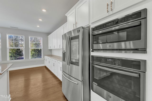 kitchen featuring stainless steel fridge, dark wood-style floors, light countertops, and white cabinetry