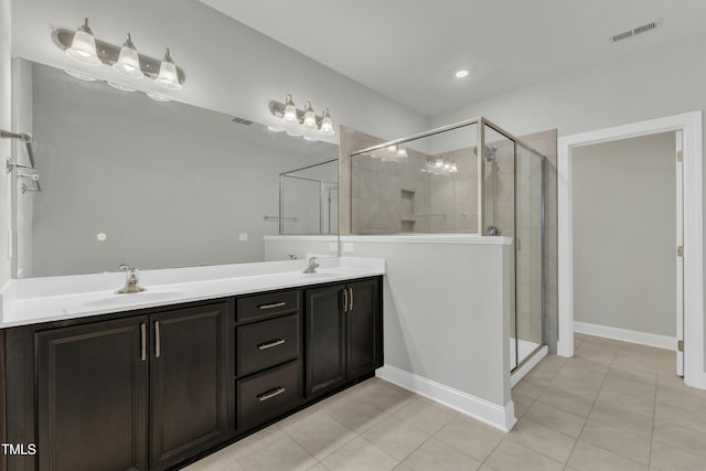 bathroom featuring a shower stall, visible vents, and a sink