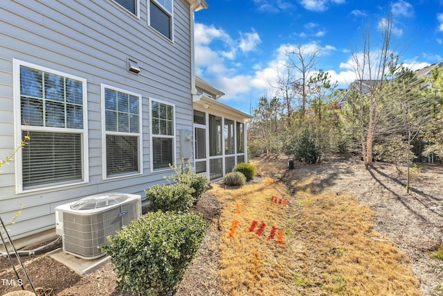 view of yard with central AC unit and a sunroom