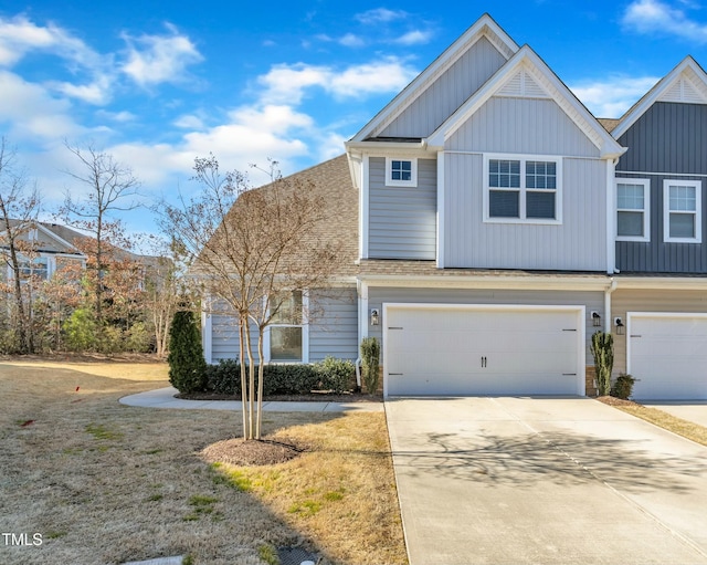 view of front of home featuring a garage, board and batten siding, concrete driveway, and roof with shingles