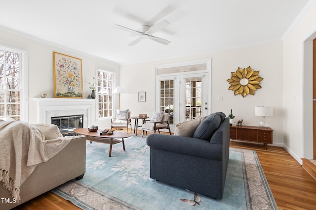 living room with wood finished floors, ceiling fan, and ornamental molding