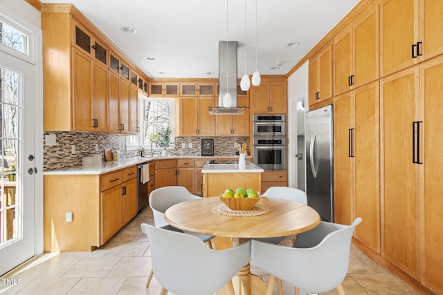 kitchen featuring decorative backsplash, appliances with stainless steel finishes, island exhaust hood, and light countertops