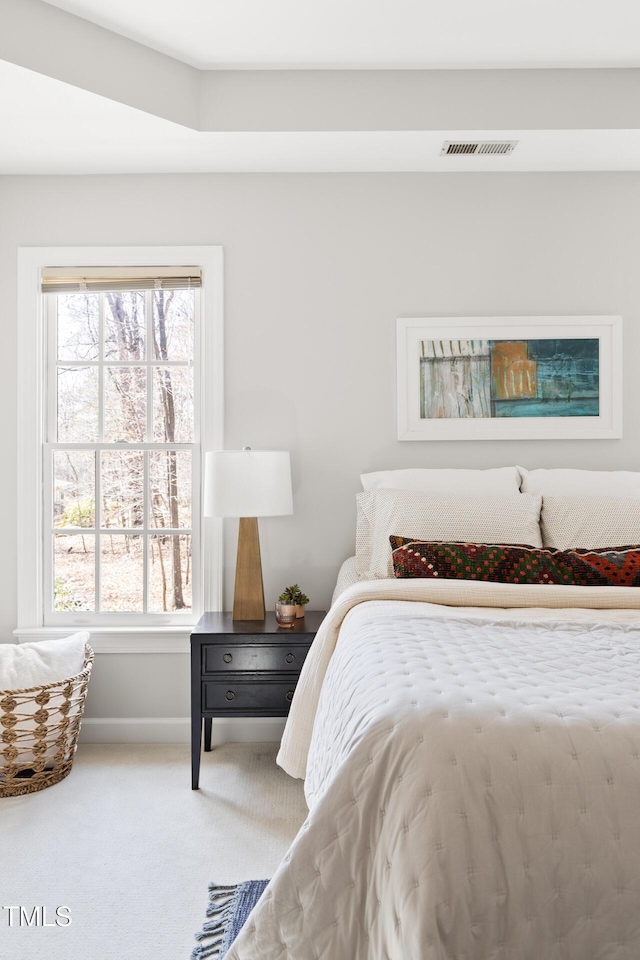 carpeted bedroom with visible vents and baseboards