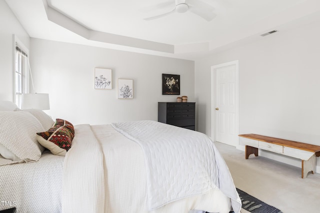 bedroom featuring visible vents, a raised ceiling, ceiling fan, and carpet floors