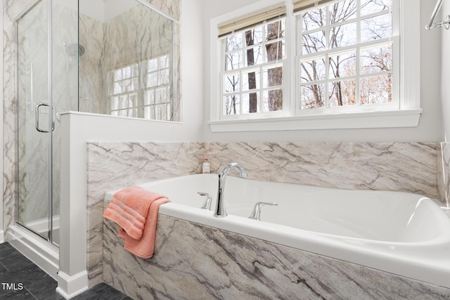full bathroom featuring a bath and a marble finish shower