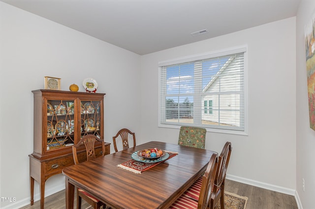 dining area featuring visible vents, baseboards, and wood finished floors