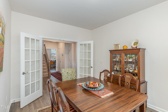 dining room featuring french doors, baseboards, and wood finished floors