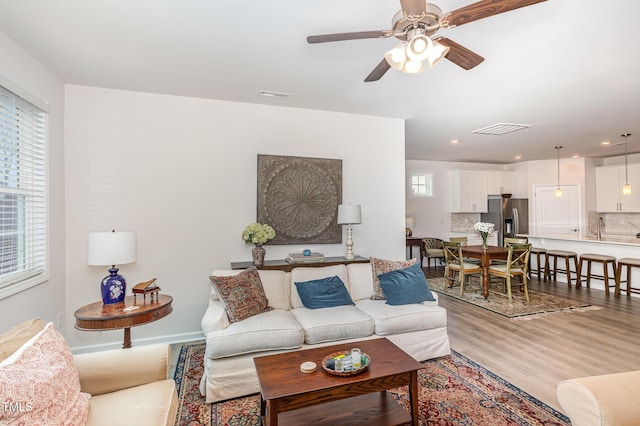 living room with a wealth of natural light, visible vents, and light wood finished floors