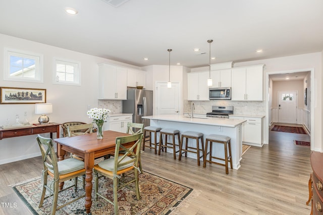 dining room with light wood-style flooring, recessed lighting, and a healthy amount of sunlight