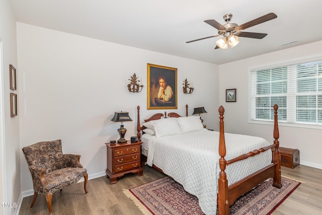 bedroom featuring a ceiling fan, light wood-style flooring, baseboards, and visible vents