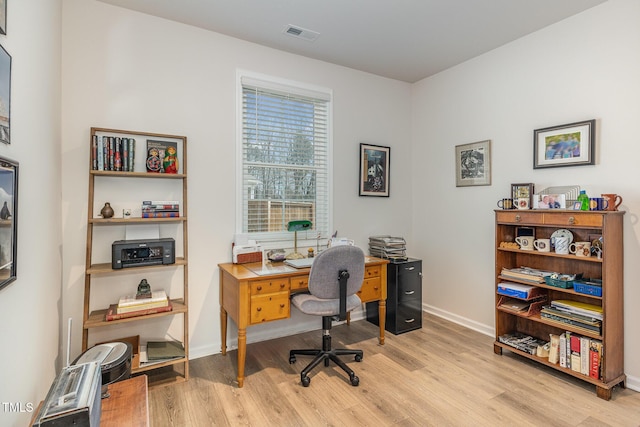 office area with visible vents, baseboards, and light wood-style floors